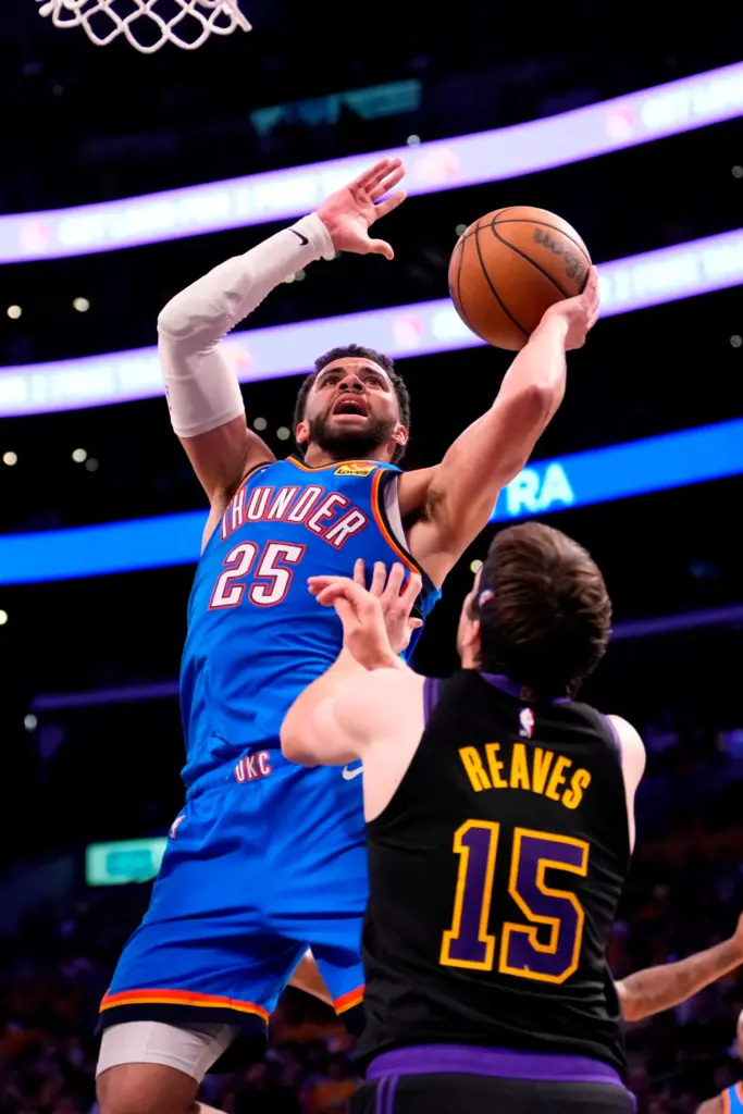 Oklahoma City Thunder guard Ajay Mitchell, left, shoots as Lakers...