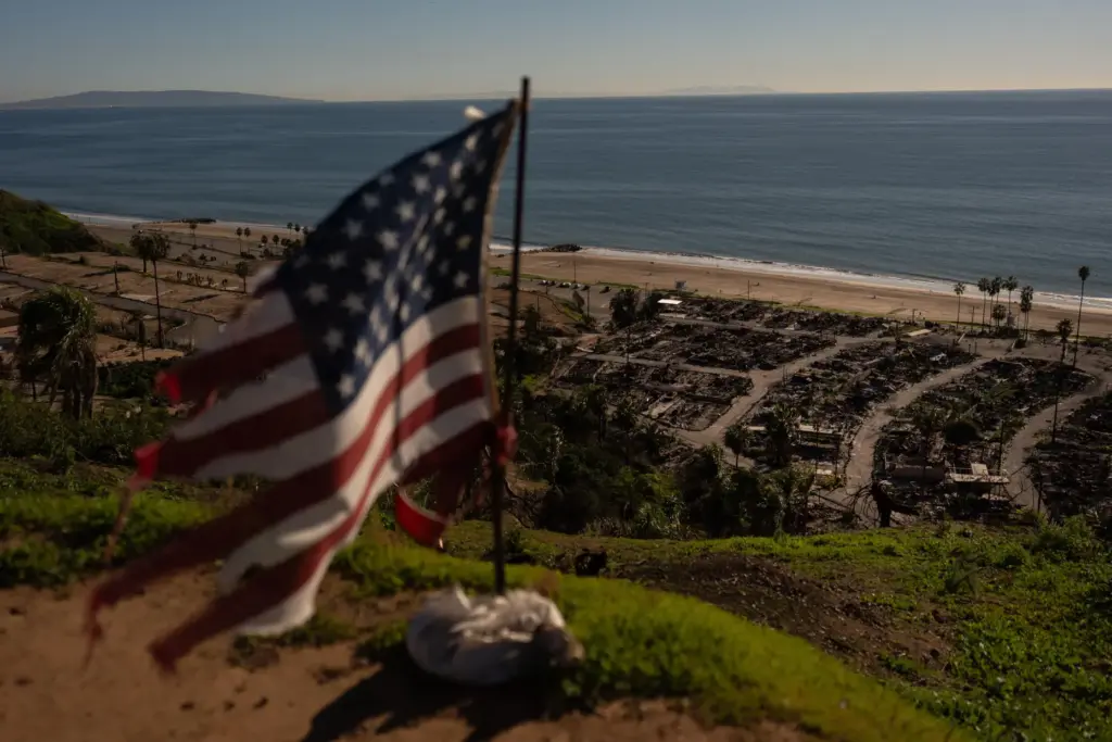 FILE – A tattered U.S. flag flaps in the wind...