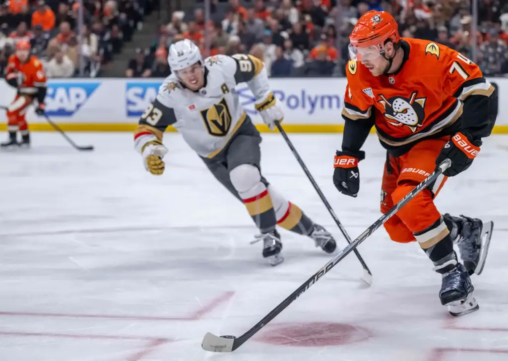 The Ducksâ John Carlson, right, controls the puck as the...