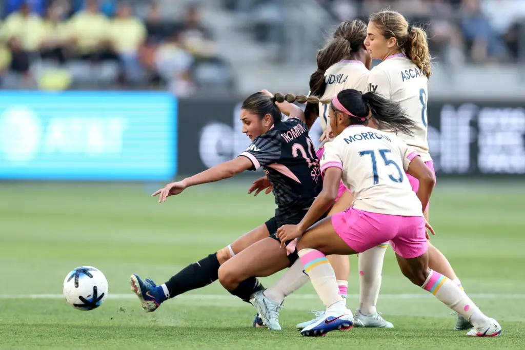 Angel City FC defender Gisele Thompson, left, kicks the ball...