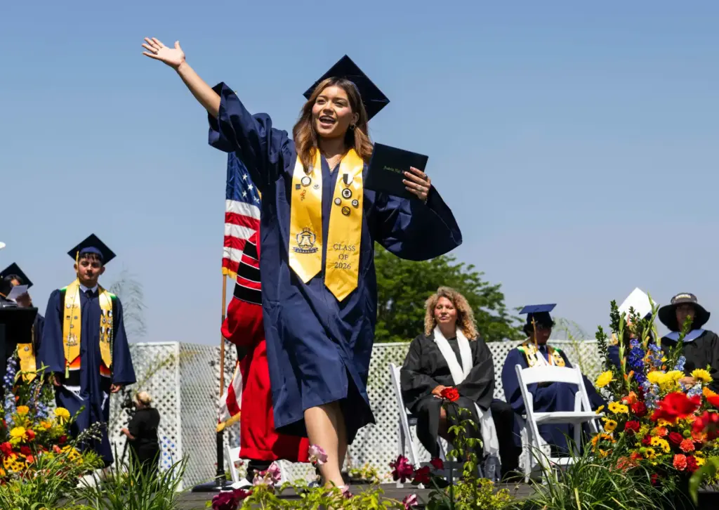 Katherine Valle waves to the crowd after receiving her diploma...