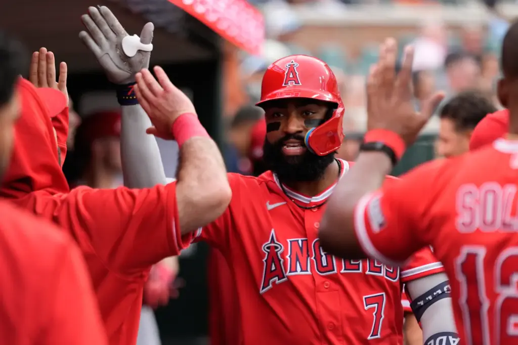 The Angels’ Jo Adell celebrates in the dugout after hitting...