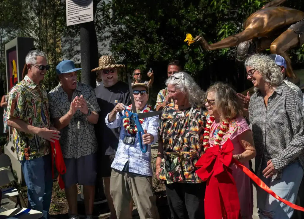 Mickey MuÃ±oz, center, has some fun cutting the ribbon for...