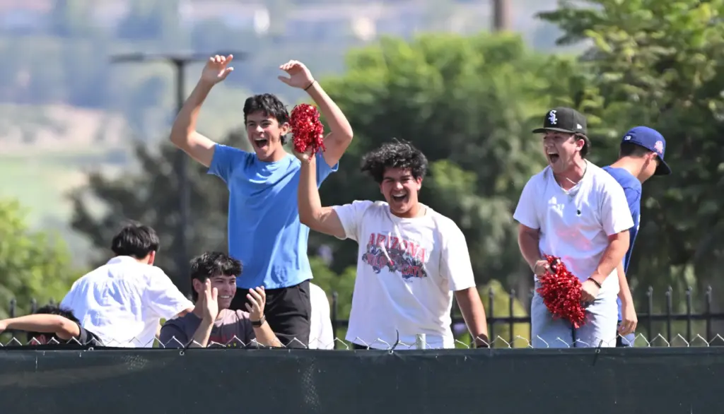 Whittier Christian Heralds fans cheer from the left field wall...
