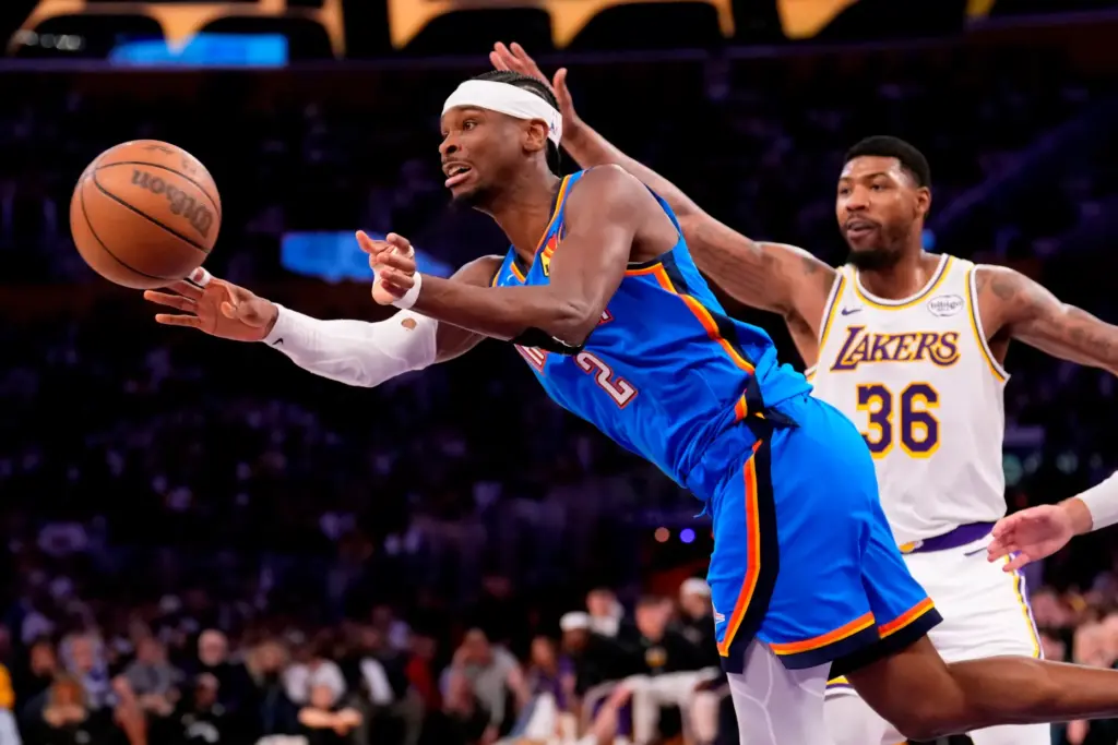 Oklahoma City Thunder guard Shai Gilgeous-Alexander, left, passes the ball...
