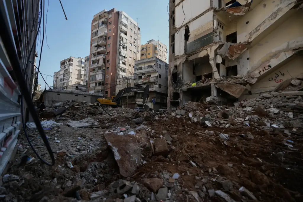 A bulldozer clears the rubble where a sports clothing shop was destroyed in an Israeli airstrike.
