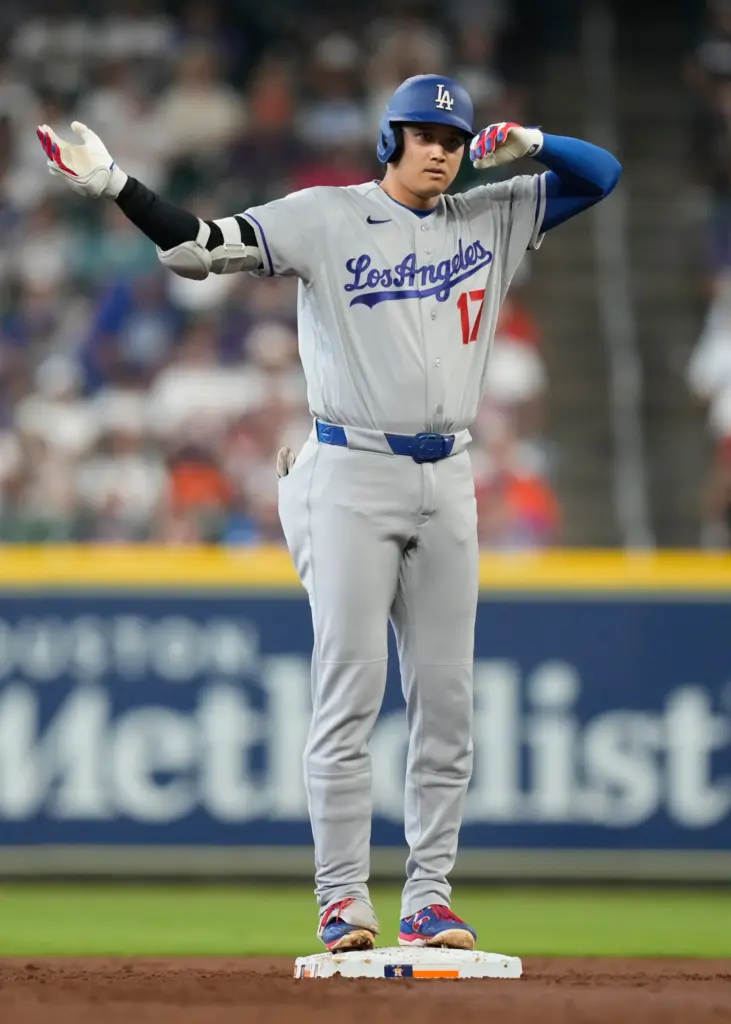 Dodgers star Shohei Ohtani gestures to his dugout after hitting...