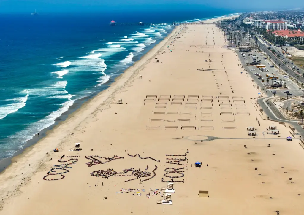 Over 1,000 kids form a giant artwork in the sand...