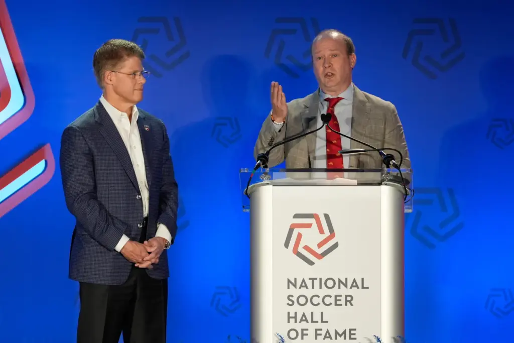 Clark Hunt, left, looks on as Dan Hunt speaks