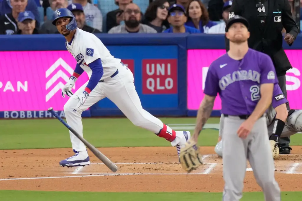 The Dodgers’ Mookie Betts, left, begins to run as he...