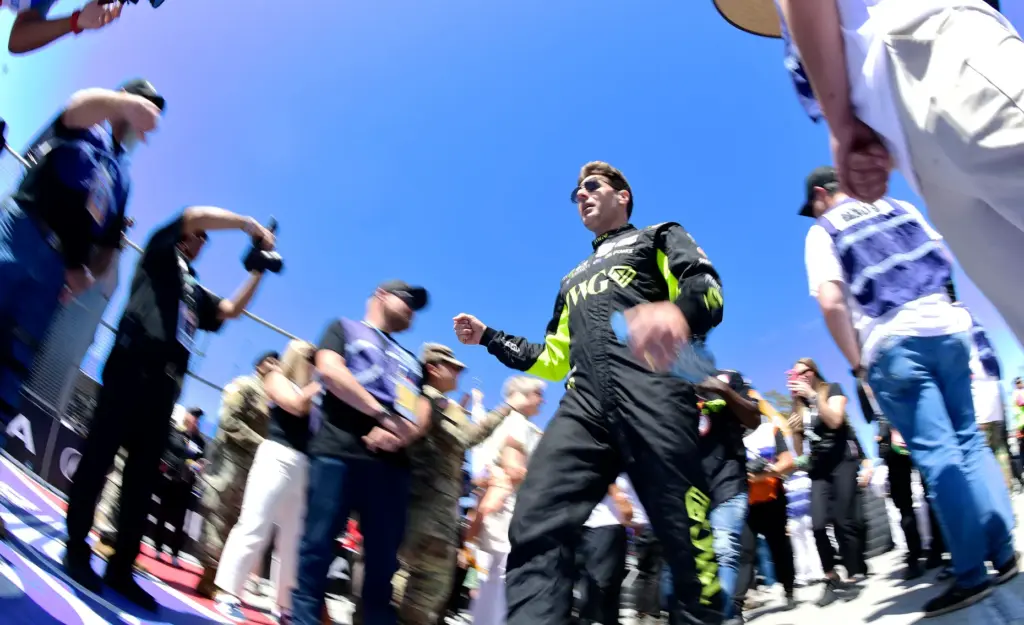 Indycar driver Will Power walks through a gauntlet of fans,...