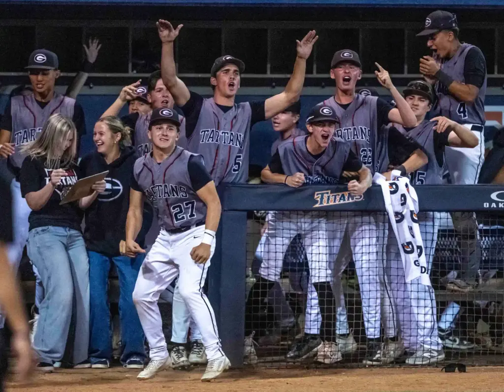 Glendora players celebrate as infielder Santiago Garza slides into home...