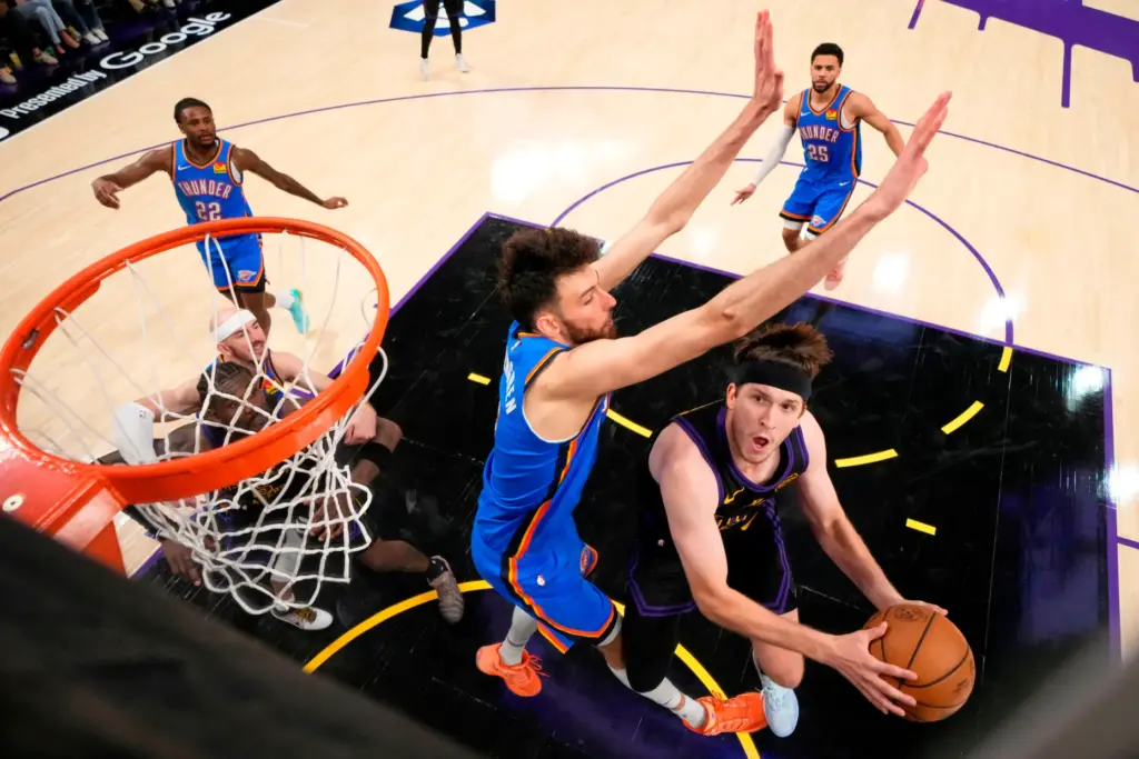 Lakers guard Austin Reaves, right, shoots as Oklahoma City Thunder...