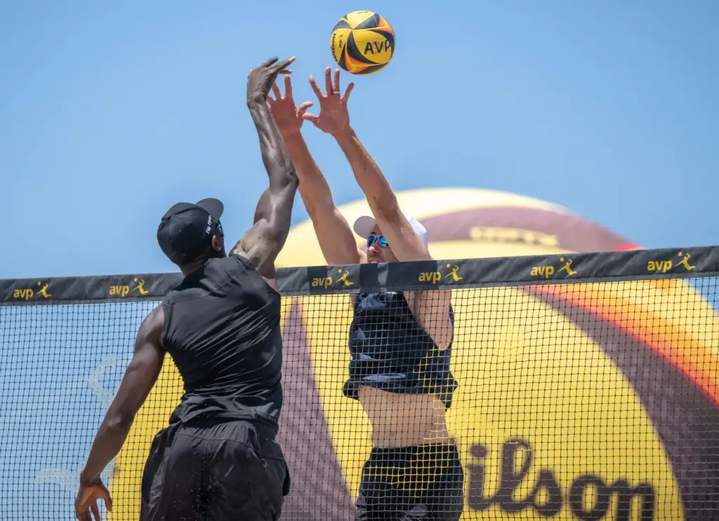 Ahmed Tijan, left, hits the ball while Andy Banish puts...