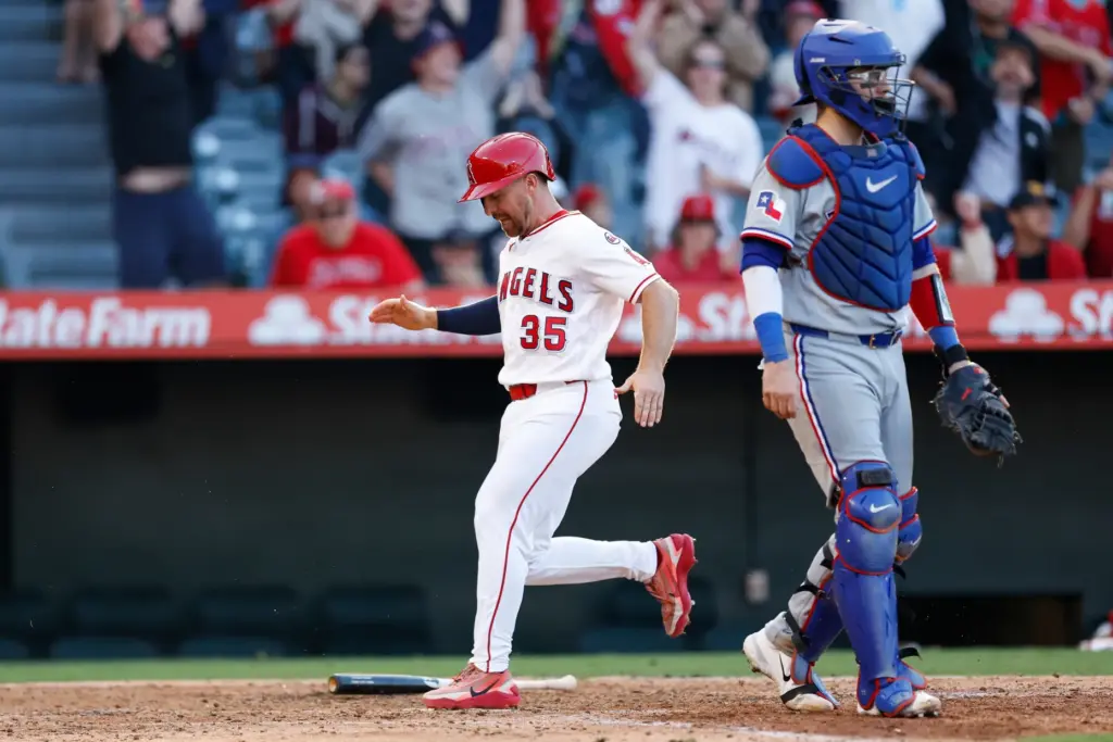 The Angels’ Donovan Walton (35) scores on a throwing error...