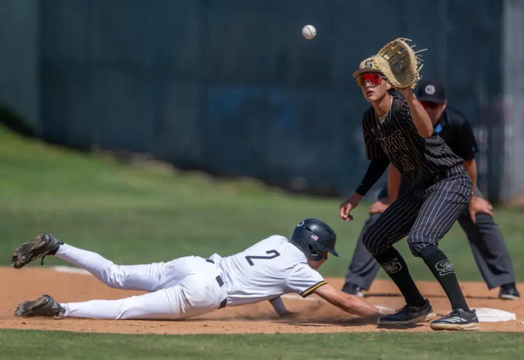 Foothill outfielder Brayden Bianchi, left, dives safely back to first...