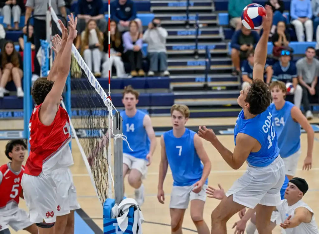 Corona del Mar outside hitter Hunter Hannemann hits the ball...
