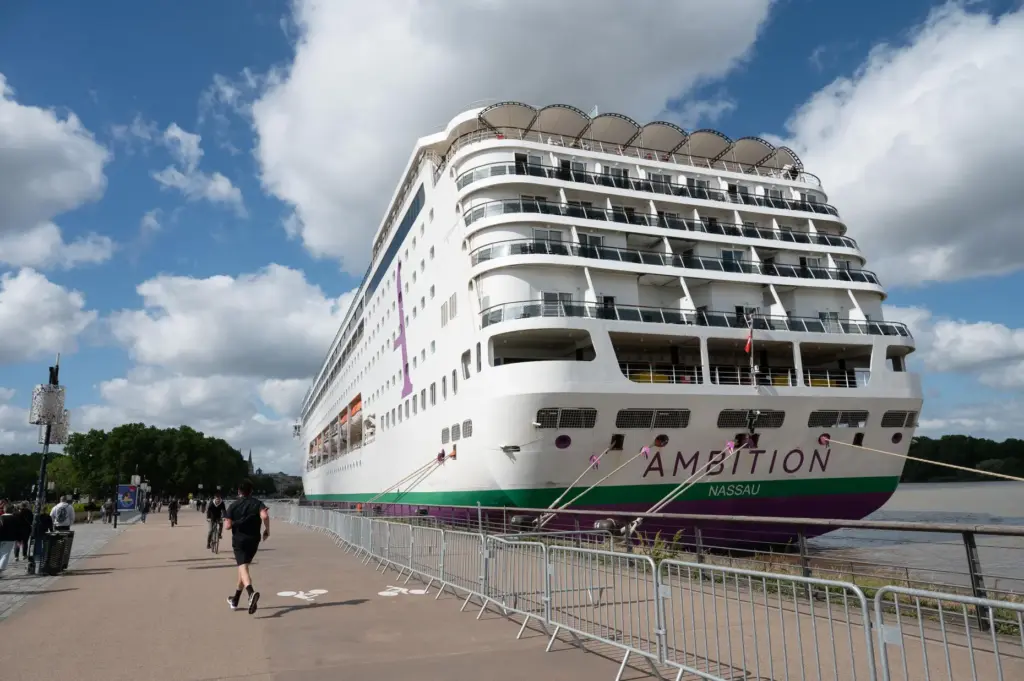 People walk past the British cruise ship Ambition, as French...