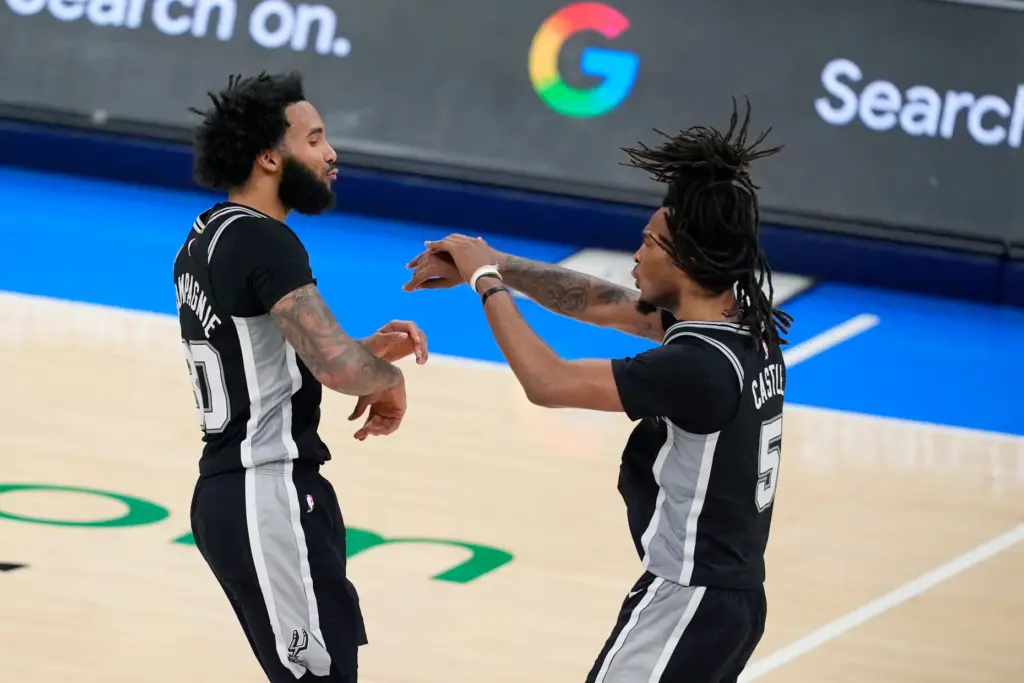 San Antonio Spurs forward Julian Champagnie, left, celebrates a 3-pointer...