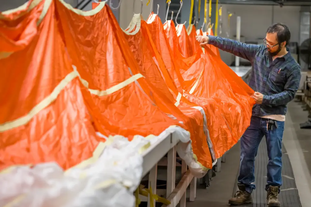 Parachute inspector Anthony-Minh Nguy examines a parachute to be used...