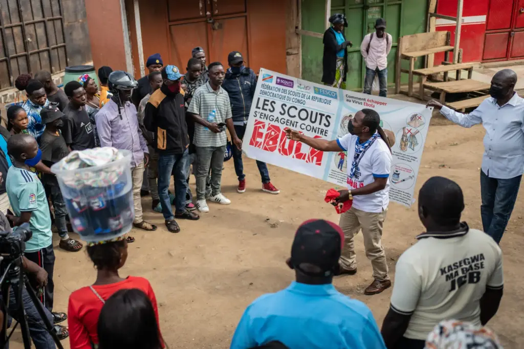 Francois Kasereka, a member of the Congo Scouts movement, speaks to people