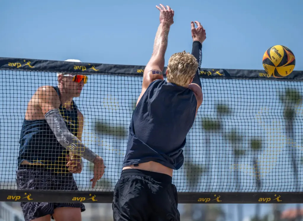 James Shaw, left, hits the ball past the block of...