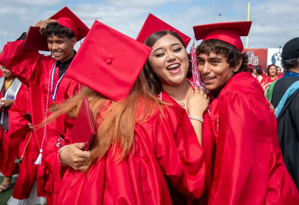 Friends have a group hug as graduates after the Garden...