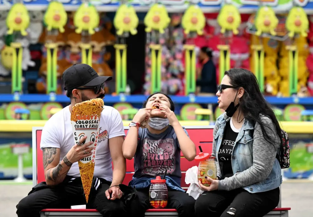 Rose Alvarado, center, 11, from Ontario, enjoys a mouth full...