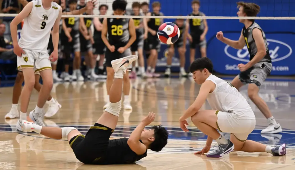 Jake Sueki, center, of the Sunny Hills Lancers canât reach...