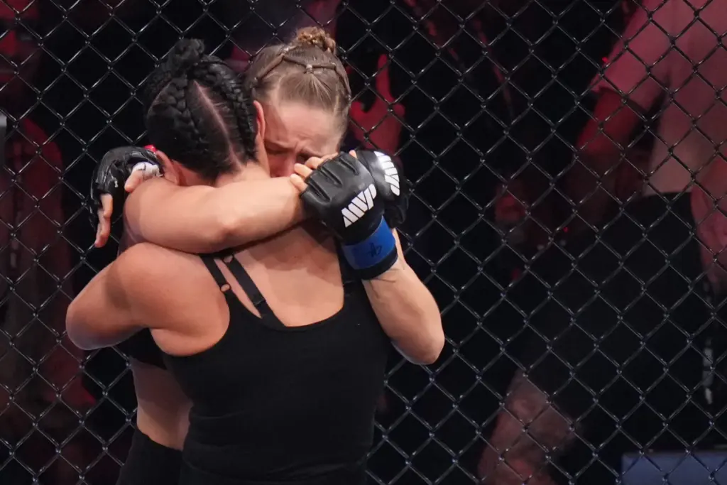 Ronda Rousey, of the United States, behind, hugs Gina Carano,...