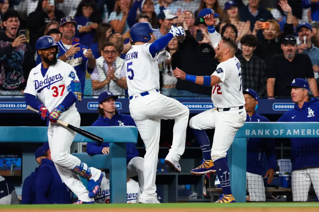 The Dodgers’ Freddie Freeman, middle, and Miguel Rojas, right, celebrate...
