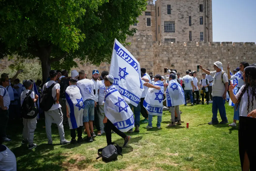 Israeli youth carrying Israeli flags gather outside Jerusalem’s Old City...
