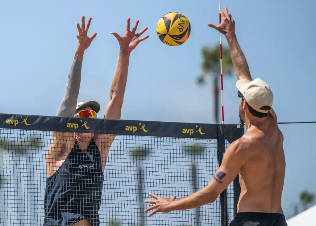Miles Evans, right, hits the ball while James Shaw puts...