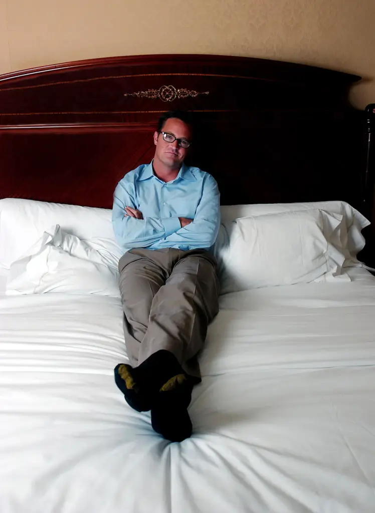 FILE – Actor Matthew Perry poses in his hotel bedroom...