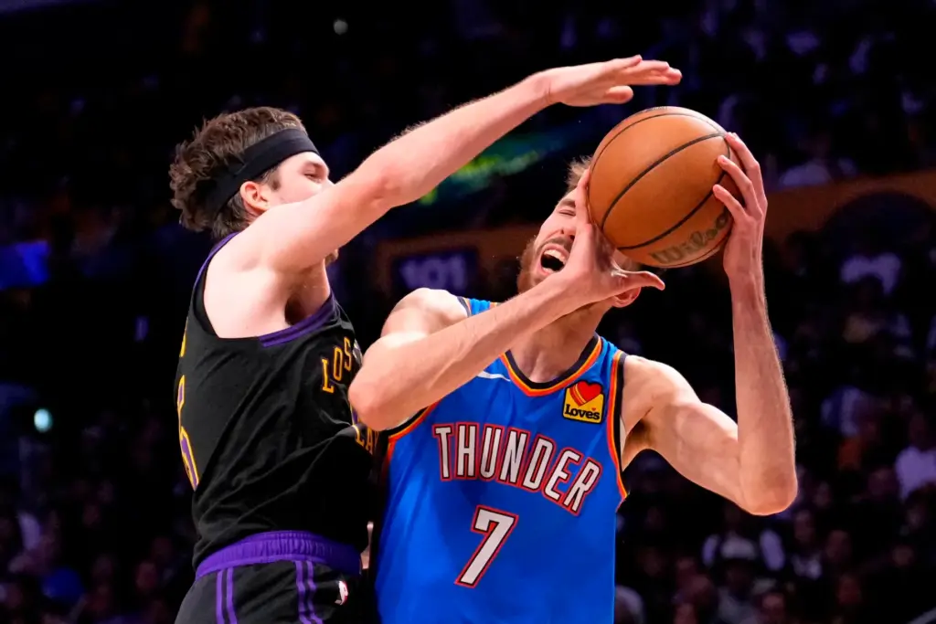 Oklahoma City Thunder center Chet Holmgren, right, tries to shoot...