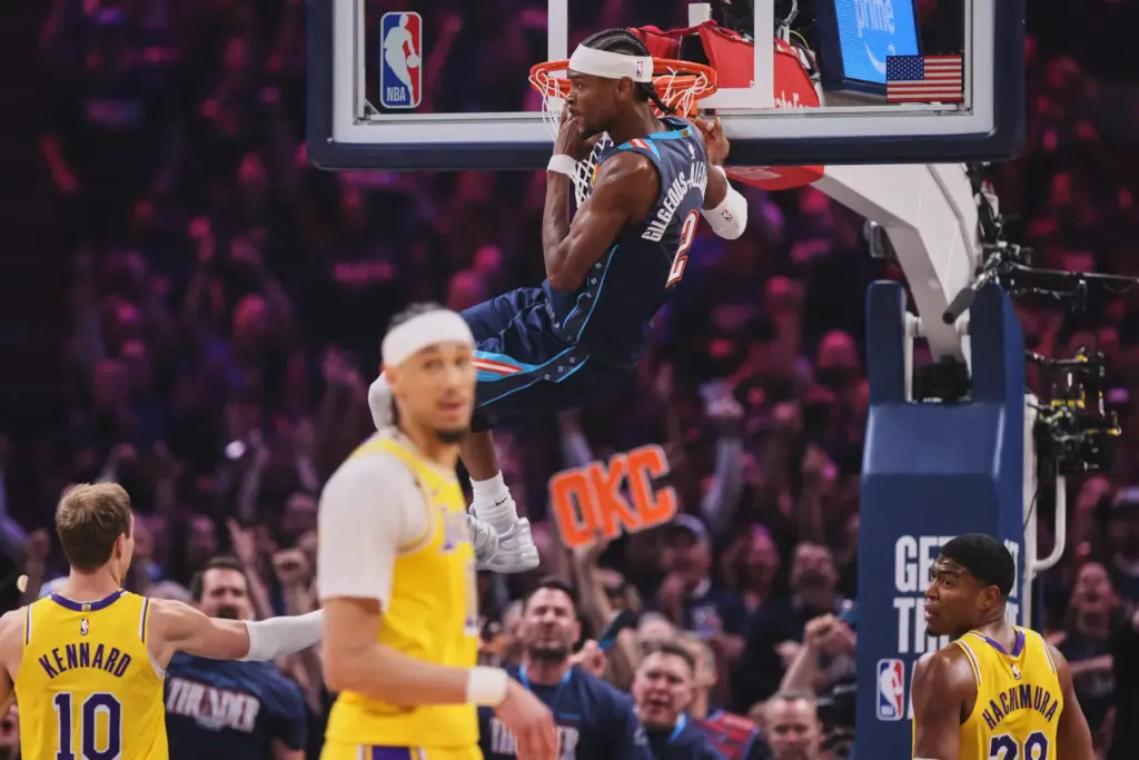 Oklahoma City Thunder guard Shai Gilgeous-Alexander hangs on the rim...