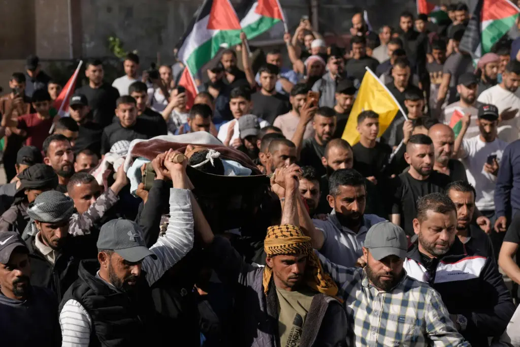 Mourners carry the body of Yousef Ka’abnah, 16, who was...
