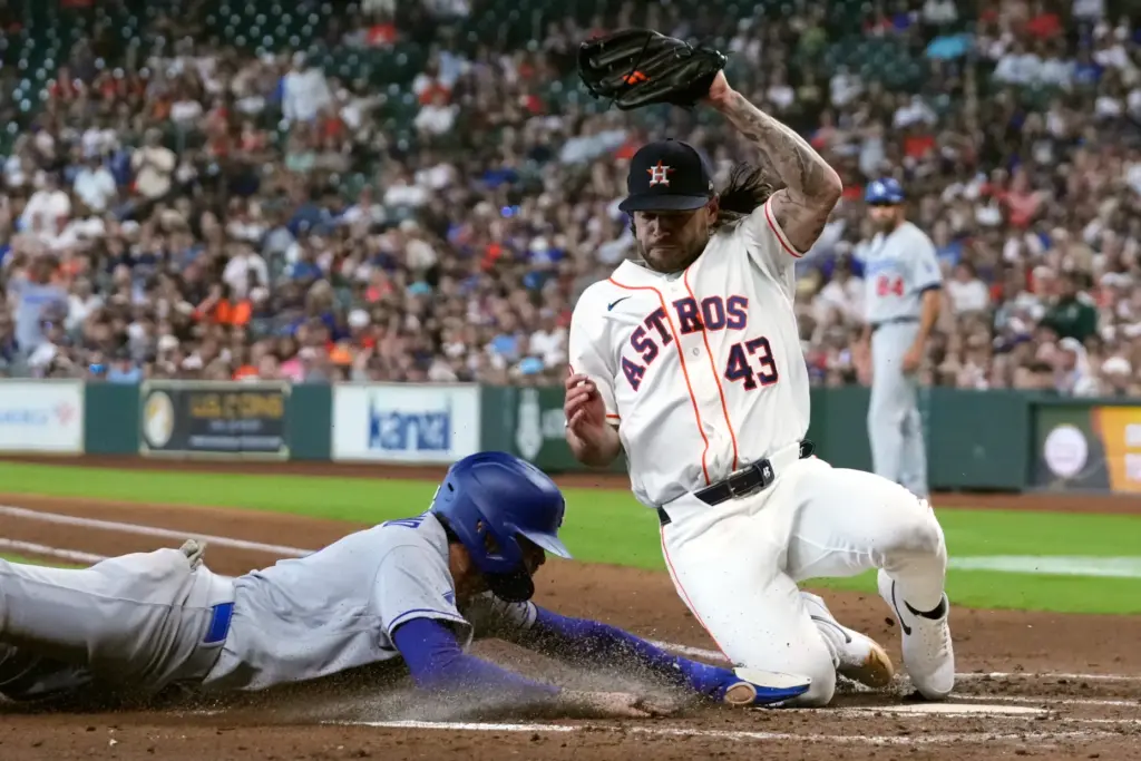 The Dodgers’ Alex Freeland, left, scores ahead of a throw...