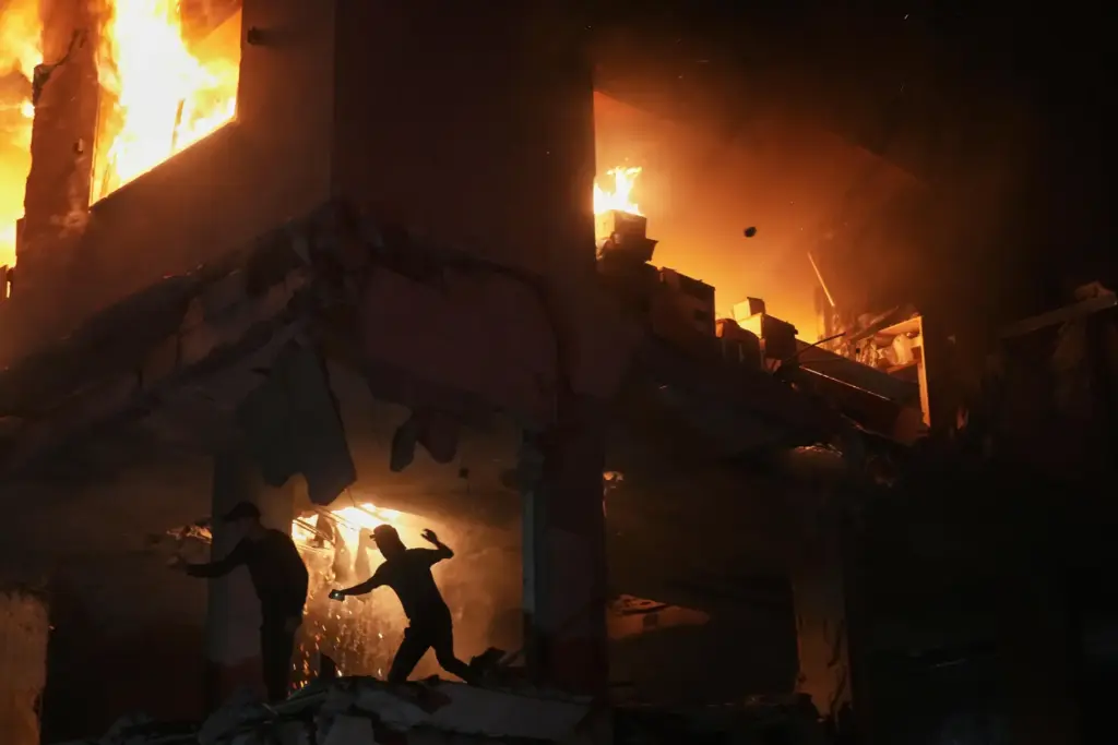 Palestinians react to a fire following an Israeli strike on a residential building.
