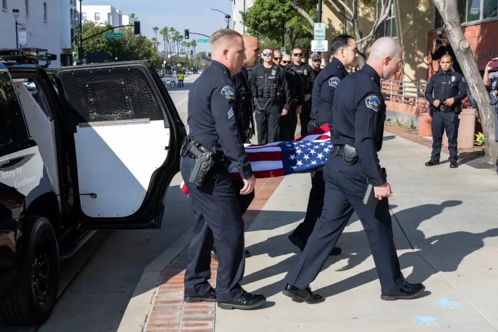 Officers carry the body of Burbank Police K-9 Spike during...