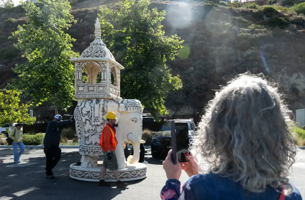 A woman takes a photo as giant chess pieces are...