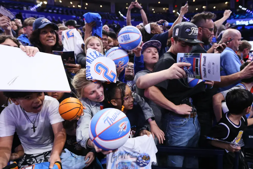 Fans gather at courtside while attempting to get autographs from...
