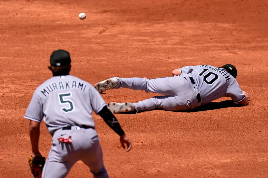 Chicago White Sox second baseman Chase Meidroth, right, falls while...