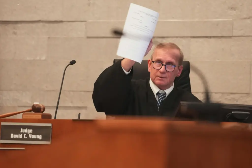 Judge David Young holds up jury instructions during closing arguments...
