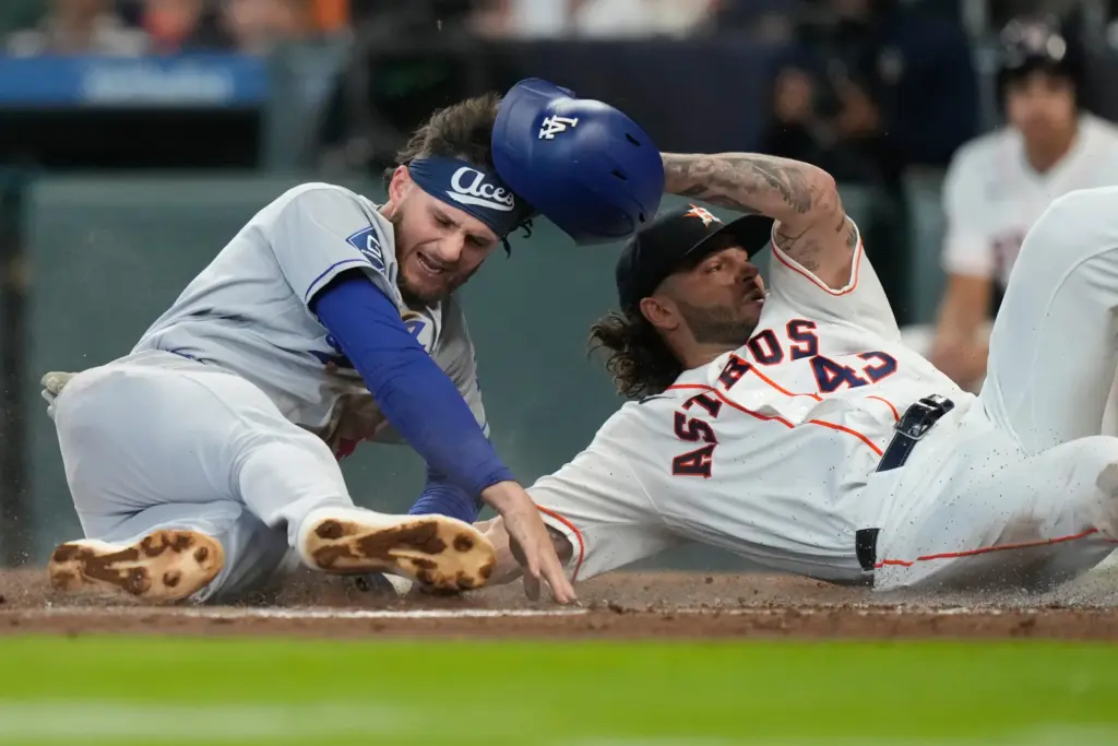 The Dodgers’ Alex Freeland, left, scores as he collides with...