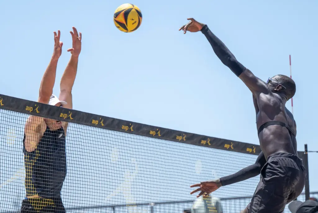 Cherif Younousse, right, hits the ball while Andy Banish puts...