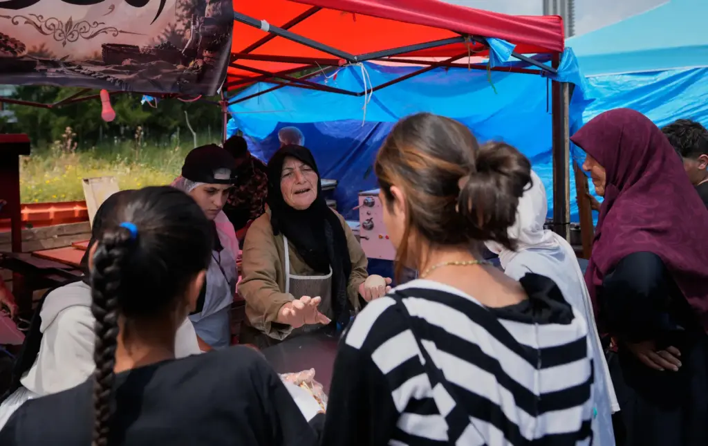 Soubhiye Zeiter speaks with displaced people who lined up to receive mana'eesh.