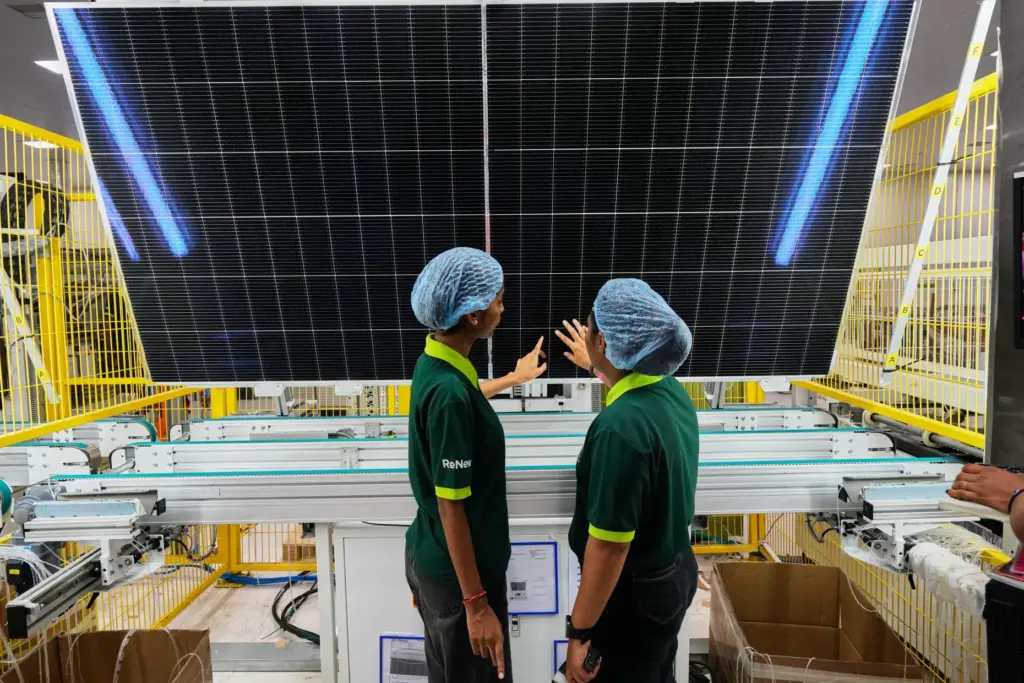Workers check the quality of a solar panel