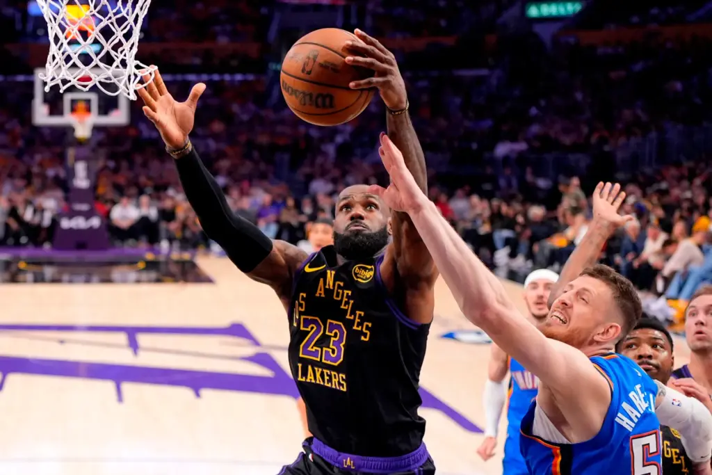 Lakers forward LeBron James, left, grabs a rebound away from...
