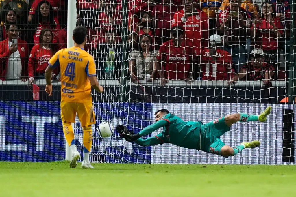 Toluca’s goalkeeper Luis Garcia, right, blocks a shot by Tigres’...